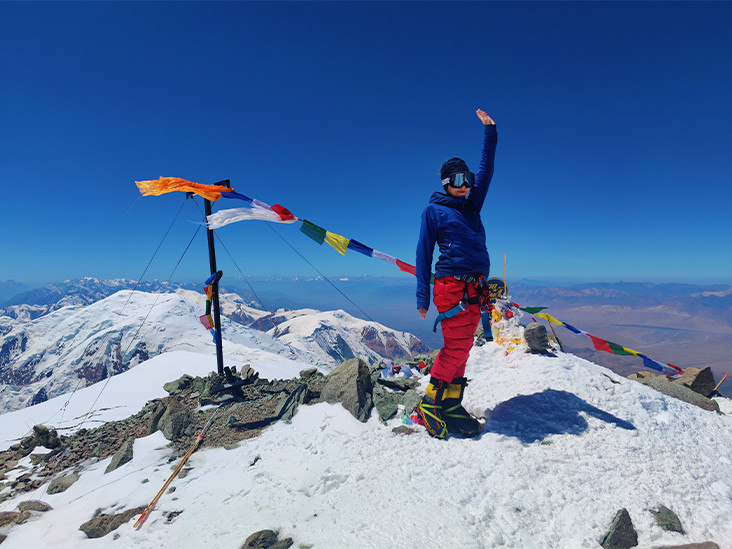 a woman mountaineer atop the summit of Lenin Peak (7,134 m)