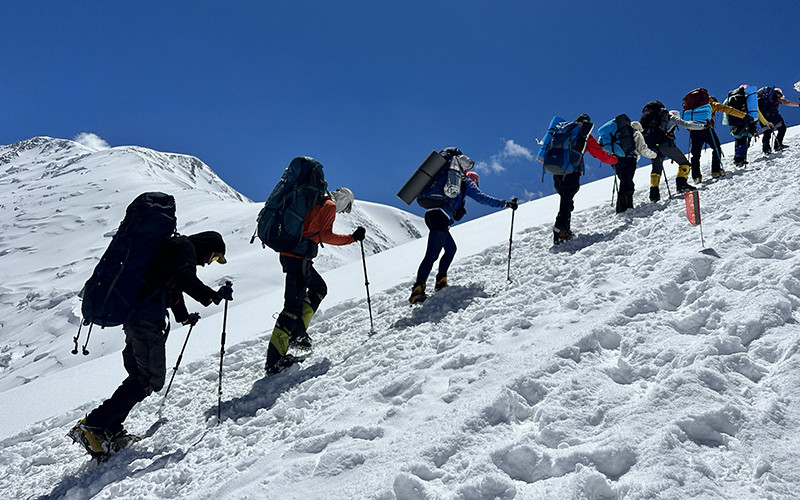 a line of mountaineers on the lenin peak expedition from Camp 2 to Camp 3